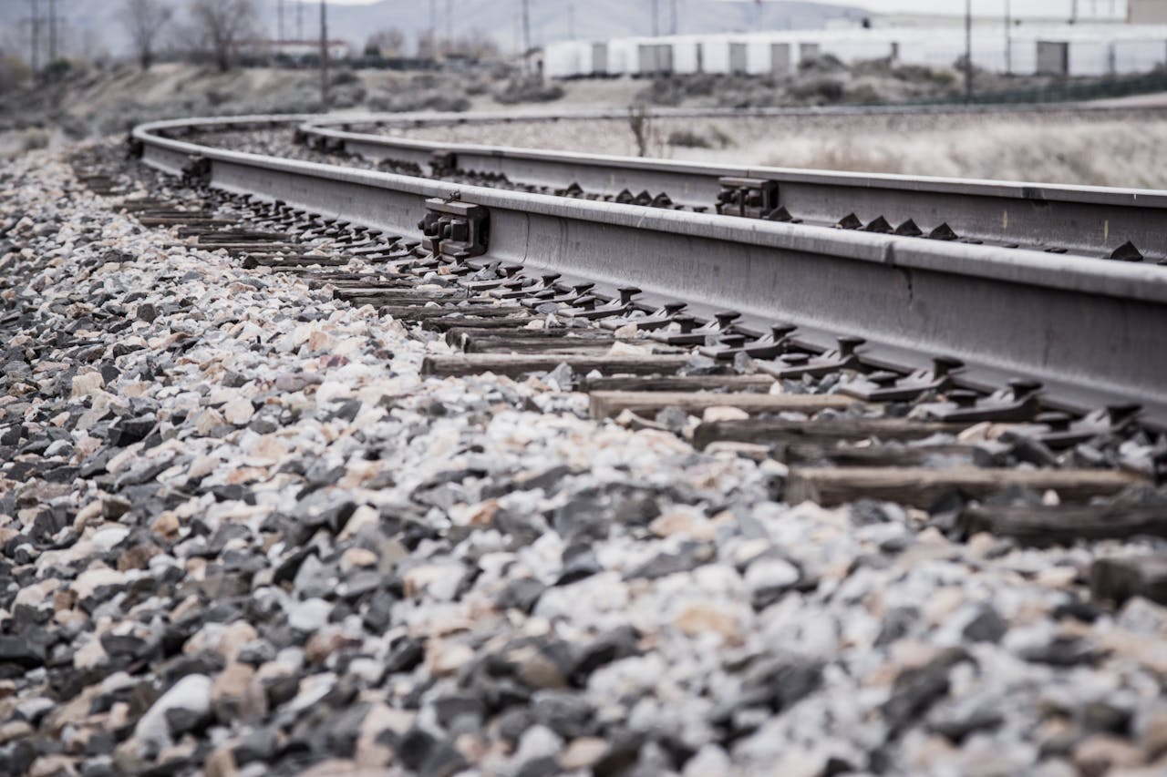 Close-up view of a curved railroad track in a rocky landscape.